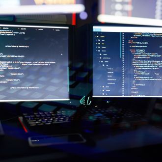 Image of two computer monitors installing the new software in dark office